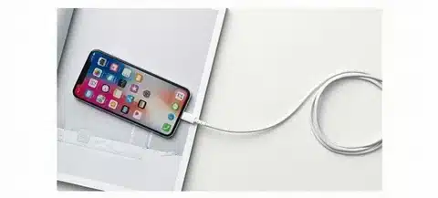 iPhone with Lightning charging cable connected.