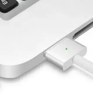 “MacBook charging via MagSafe 2 connector with LED indicator light on”