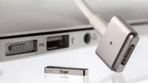 “Macro view of MagSafe 2 connector and MacBook port alignment with magnetic charging pins”