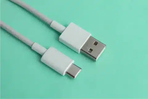“White USB Type-A to USB Type-C cable on green background.”