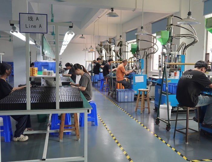 Workers assembling custom cables on production line at Kingda Cables factory