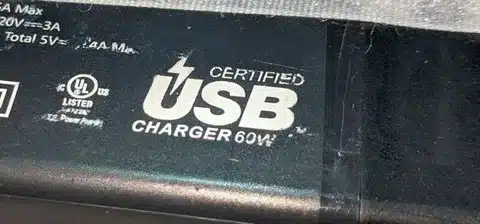 Close-up of USB charger showing USB-IF certified logo for compliance and safety.