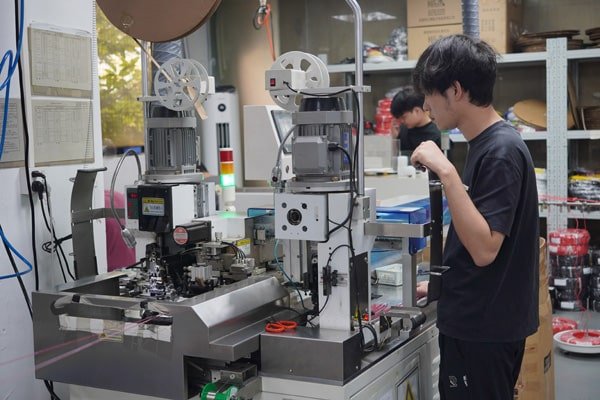 Technician operating automated cable production equipment at Kingda Cables factory