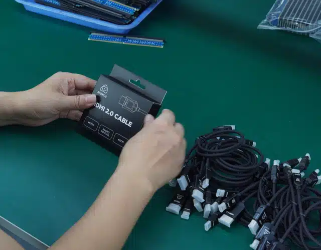 Hands packaging HDMI 2.0 cables at Kingda Cables factory with batch of finished custom cables ready for supply