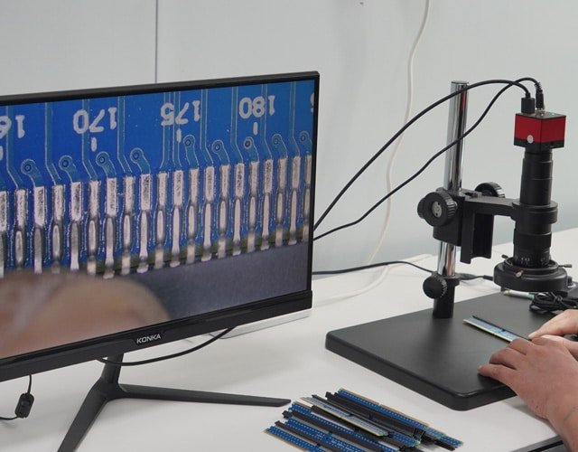 Engineer at Kingda Cables inspecting cable connectors under microscope for precision quality control