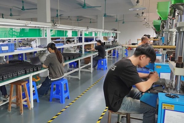 Workers assembling and processing custom cables on the production line at Kingda Cables factory
