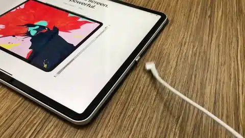 iPad Pro on wooden table with disconnected USB-C cable not charging