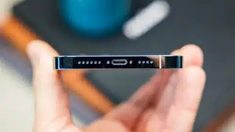 person holding iPhone 15 showing USB-C port and design details