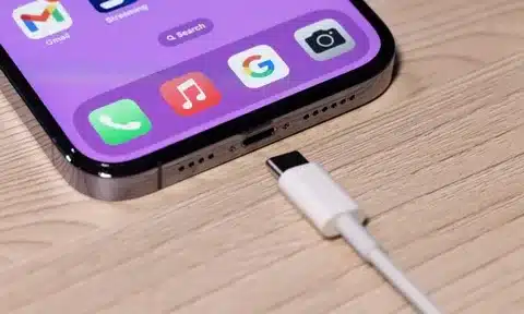 USB-C cable plugged into iPhone charging port on desk surface
