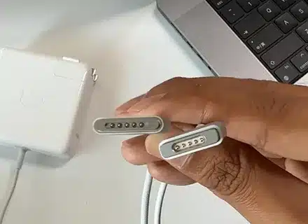 Hand holding MagSafe 2 and MagSafe 3 connectors for comparison
