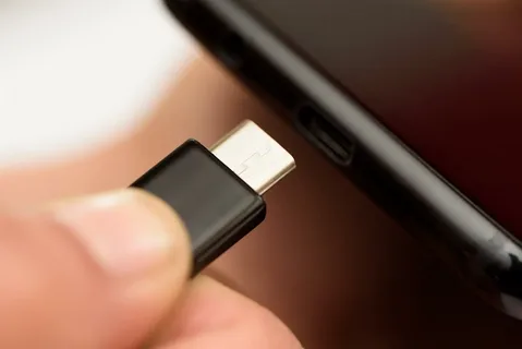 hand inserting USB-C adapter into Android phone port