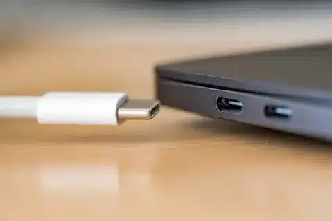USB-C cable close to laptop USB-C ports on wooden desk